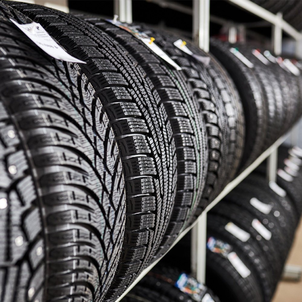 Reifen mit Profilmuster hängen in einem Regal in einer Auto-Werkstatt